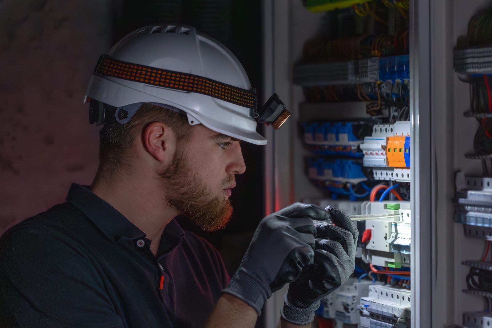 Électricien diagnostiquant une panne électrique urgente sur un tableau